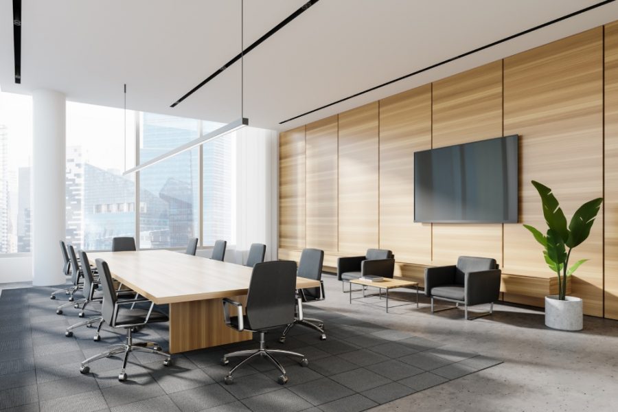 Corner of panoramic meeting room with white and wooden walls, concrete floor, long conference table and lounge area with TV and armchairs. Blurry cityscape. 3d rendering